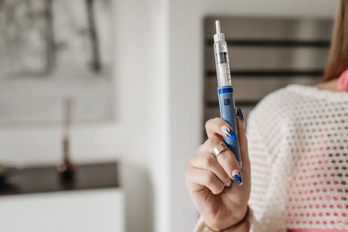 Mână care ține un stilou injector pentru insulină