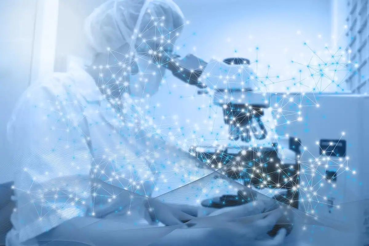 Cercetător în halat privește la microscop, cu puncte luminoase digitale în imagine