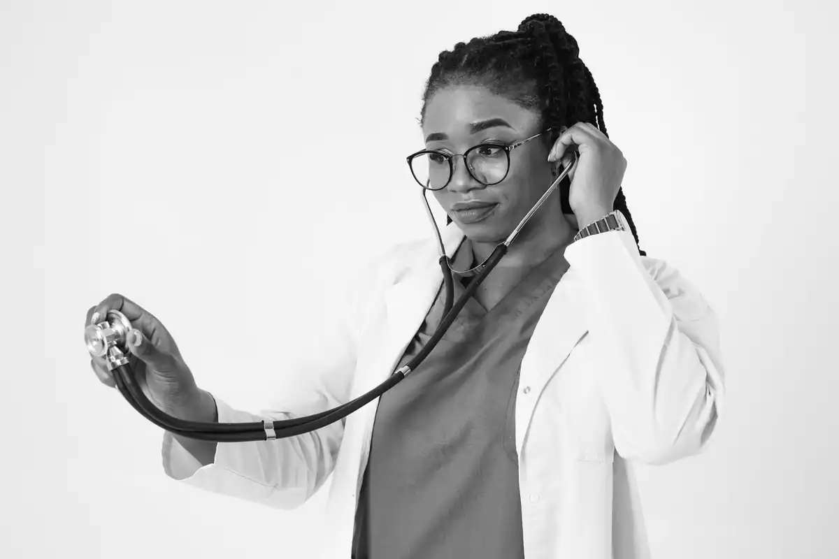 Portret al unei doctorițe concentrate, care folosește un stetoscop, într-un studio