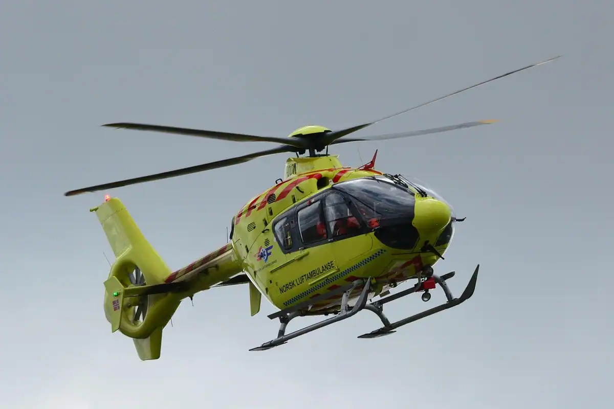 Elicopter de salvare galben cu verde, în zbor pe cer senin