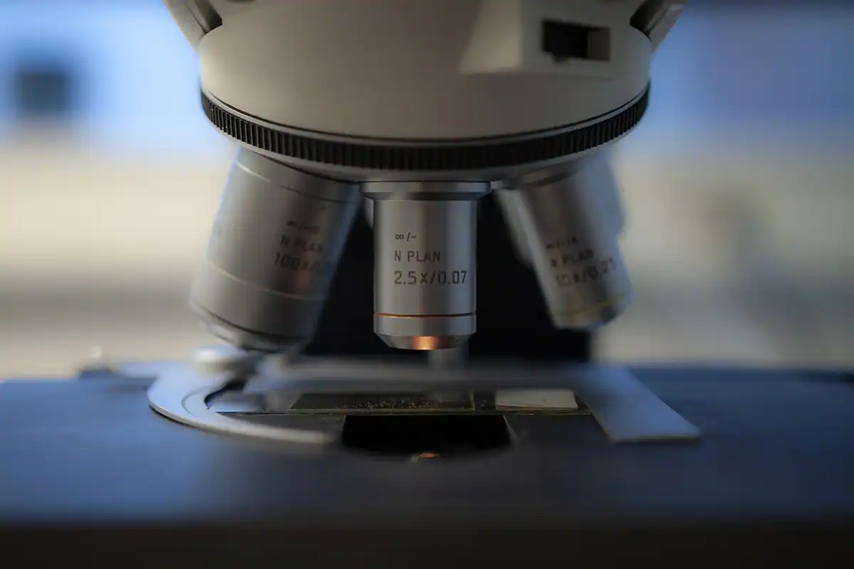 Obiectivele unui microscop, văzute de aproape, pe un blat întunecat